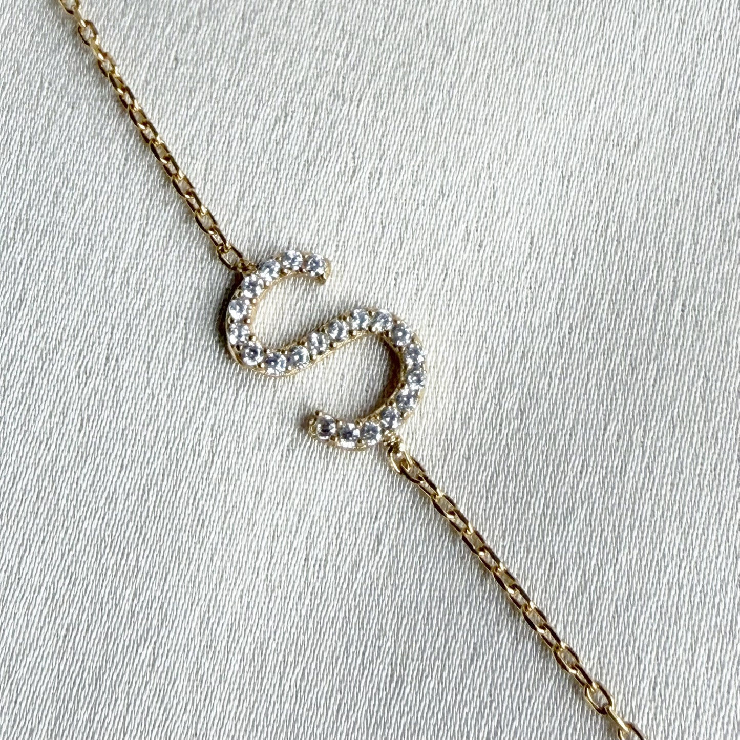 Gold necklace with a letter S made from cubic zirconia crystals
