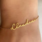 Gold name bracelet with the name 'Claudia' on a person's wrist