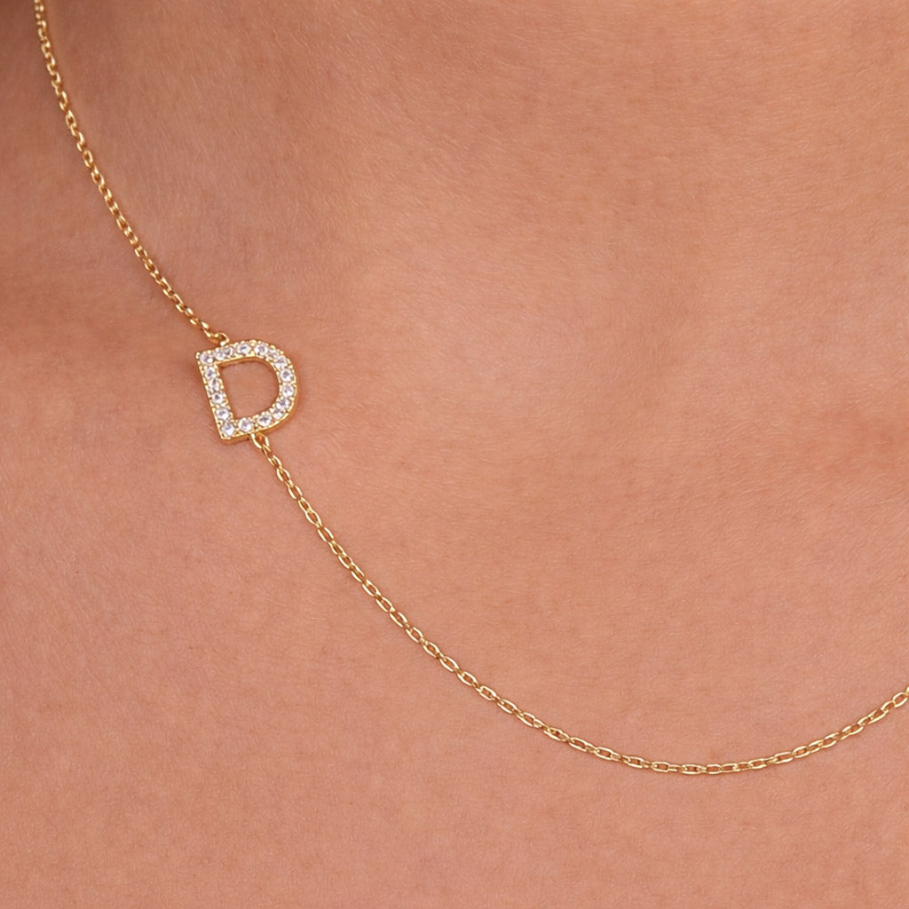 Gold necklace with cz pavé initial set sideways on a delicate chain