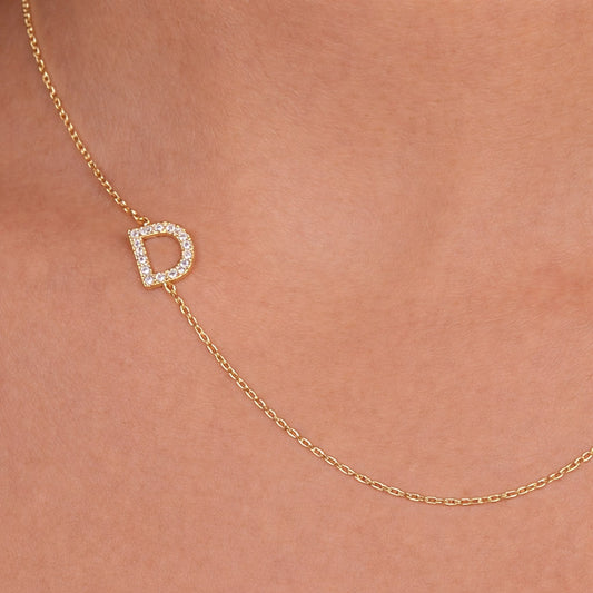 Gold necklace with cz pavé initial set sideways on a delicate chain